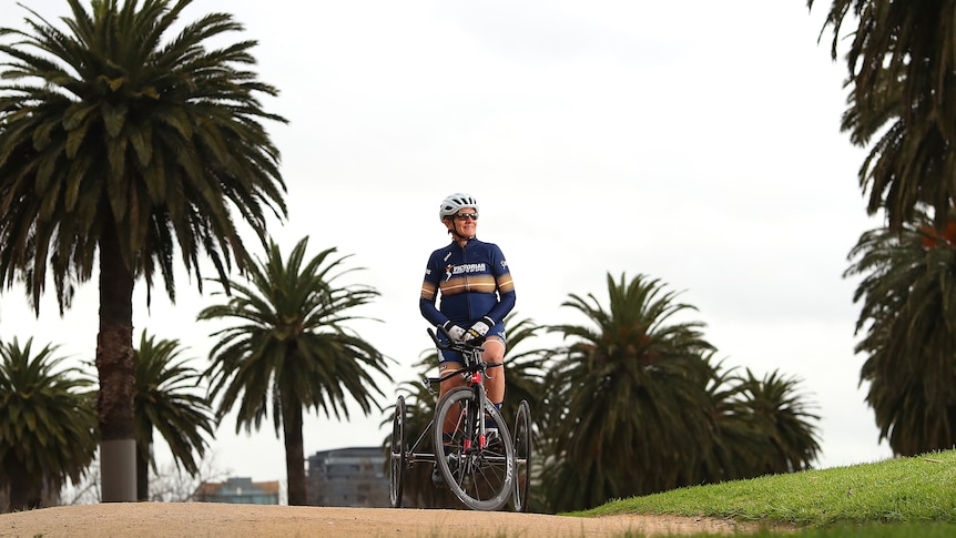 Female cyclist sitting on her bike with her representative uniform on in a park