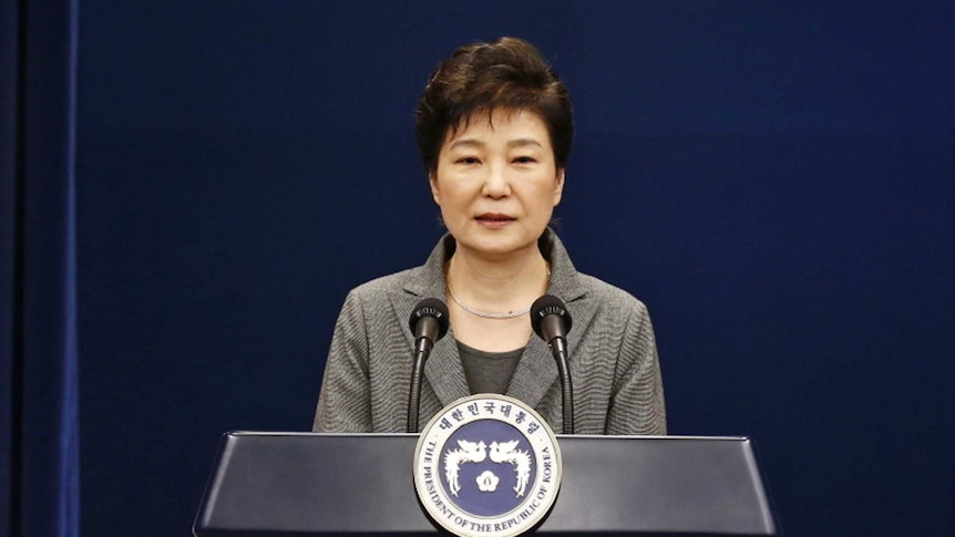 Park Geun-hye at the podium next to the South Korean flag.