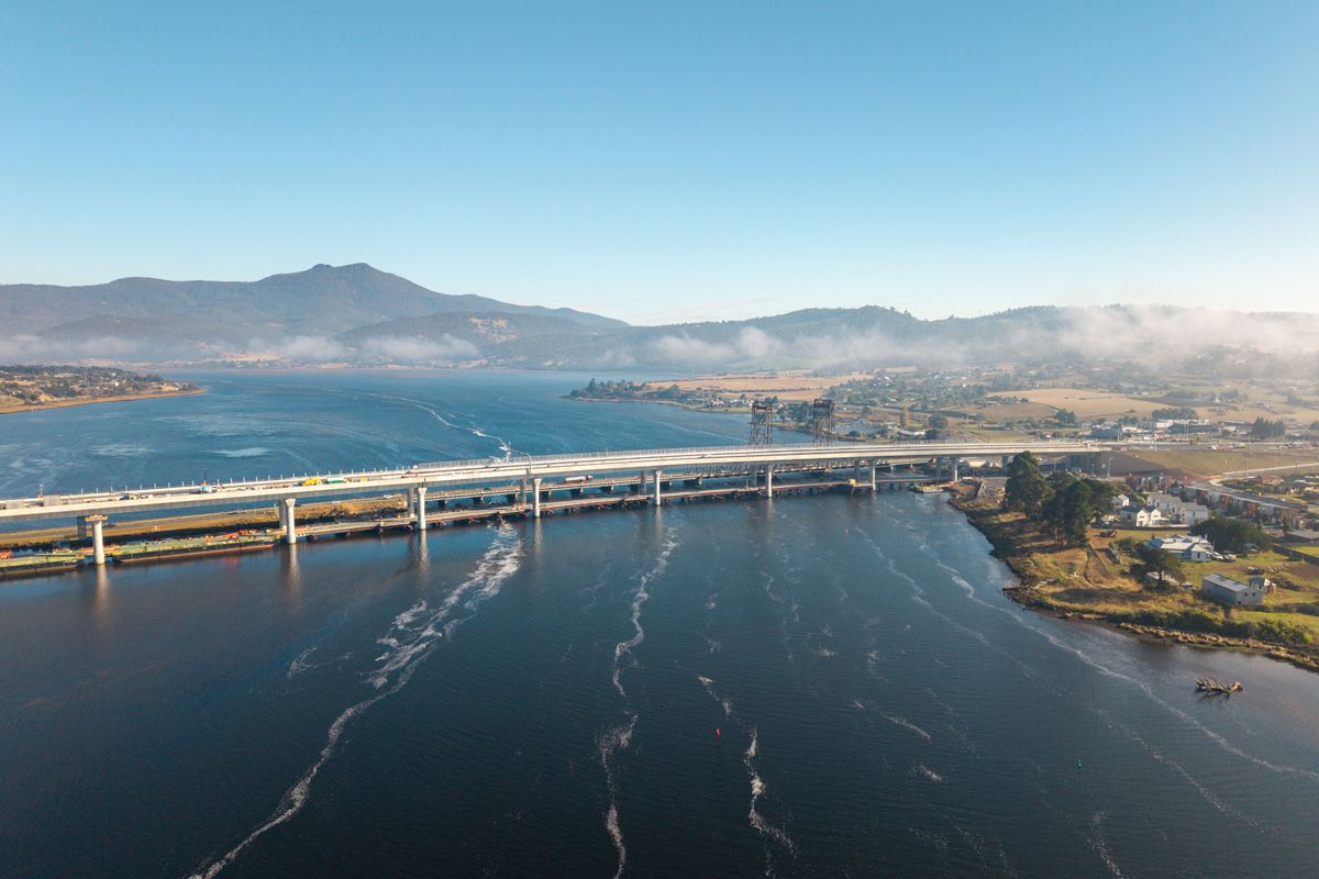 Una vista aérea de un nuevo puente de hormigón que cruza un ancho río.