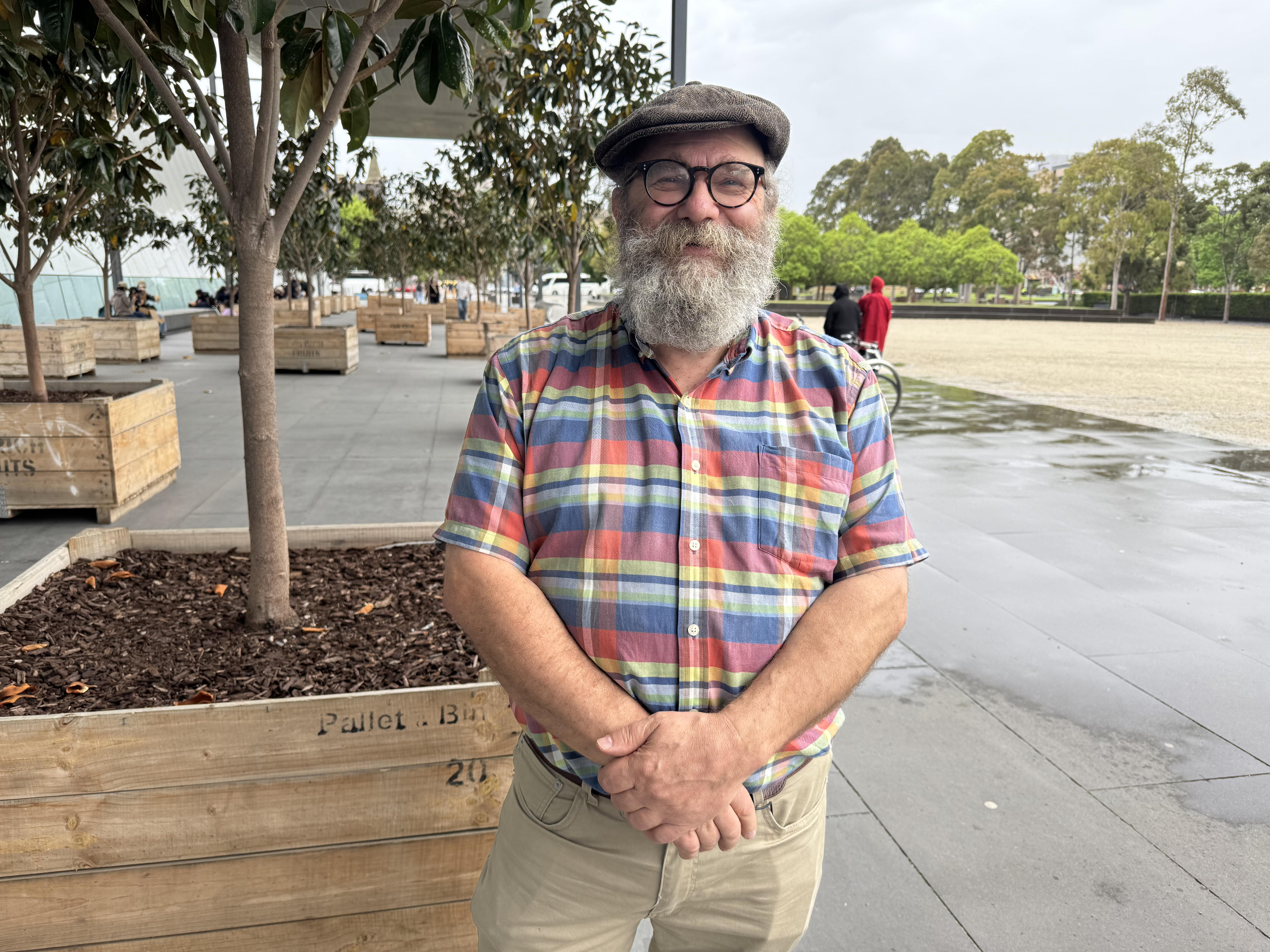 A smiling man with heavy beard and checkered shirt