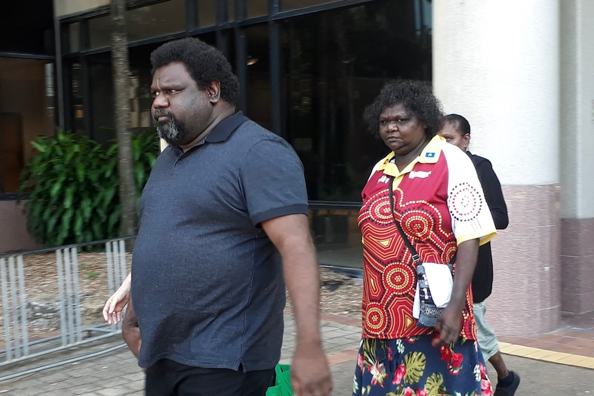 a group of people walk out of a courthouse