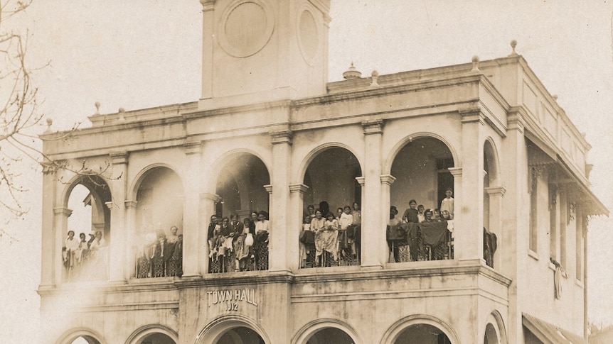 People stand on a balcony of a Town Hall