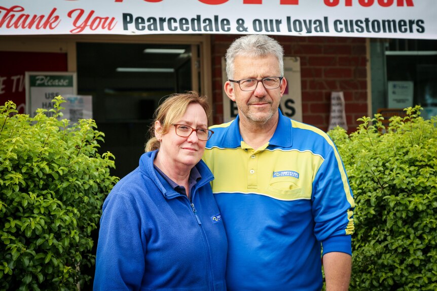 A close-up of a couple outside their hardware store