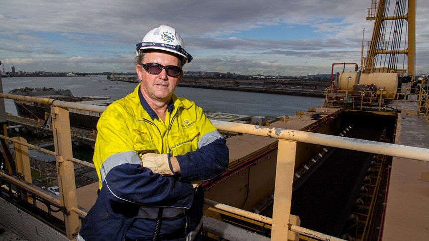 Trevor Hulse stands above a conveyor belt carrying coal.