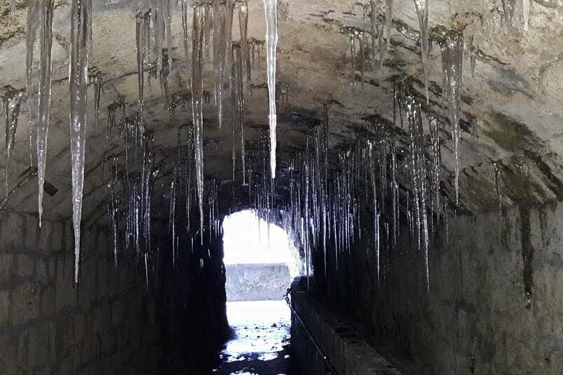 Frozen water on the ceiling of a tunnel inside the waterfall.