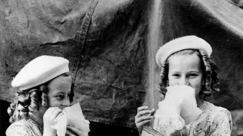 Two young girls in black and white holding Ekka showbags in 1946