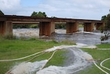 A bridge with a swollen river underneath.