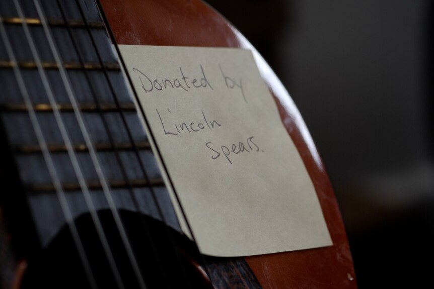 note on a guitar saying 'donated by Lincoln Spears'