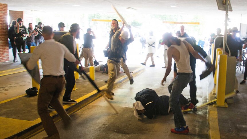 DeAndre Harris is beaten by a group of people in a parking garage next to the city police station.