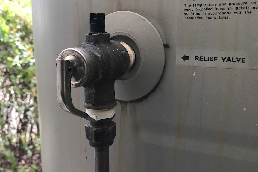 A pressure relief valve attached to a hot water system.