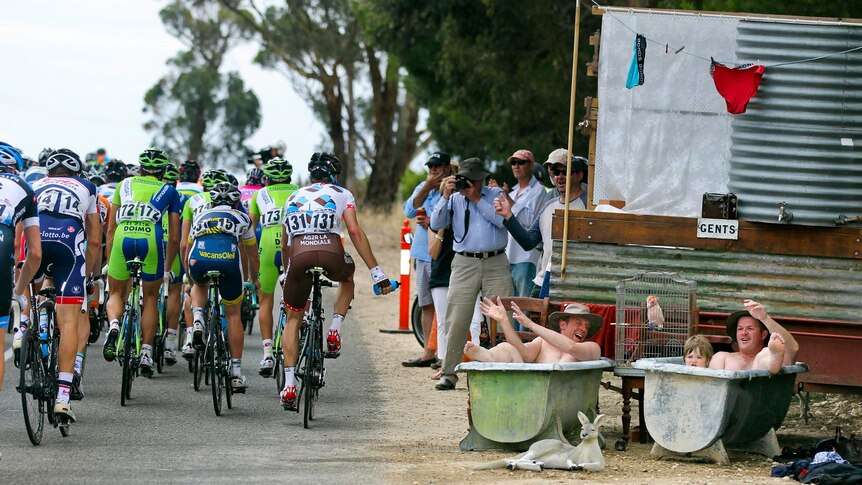 The peleton rides past spectators in bathtubs during stage one of the Tour Down Under in Clare.