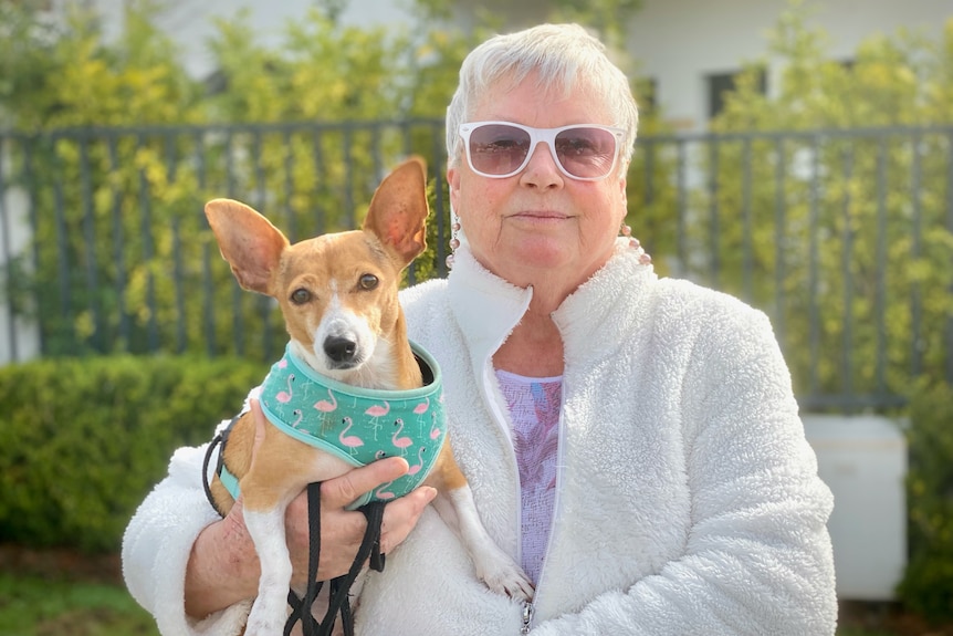 Kathryn Firth holding her little dog and both looking at the camera