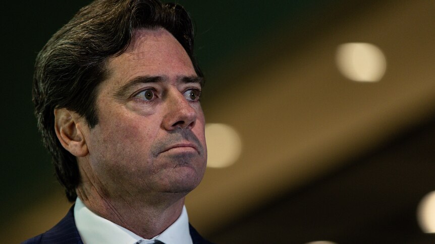 Facing right from the left of image, Gillon McLachlan wears a serious face.