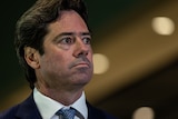 Facing right from the left of image, Gillon McLachlan wears a serious face.