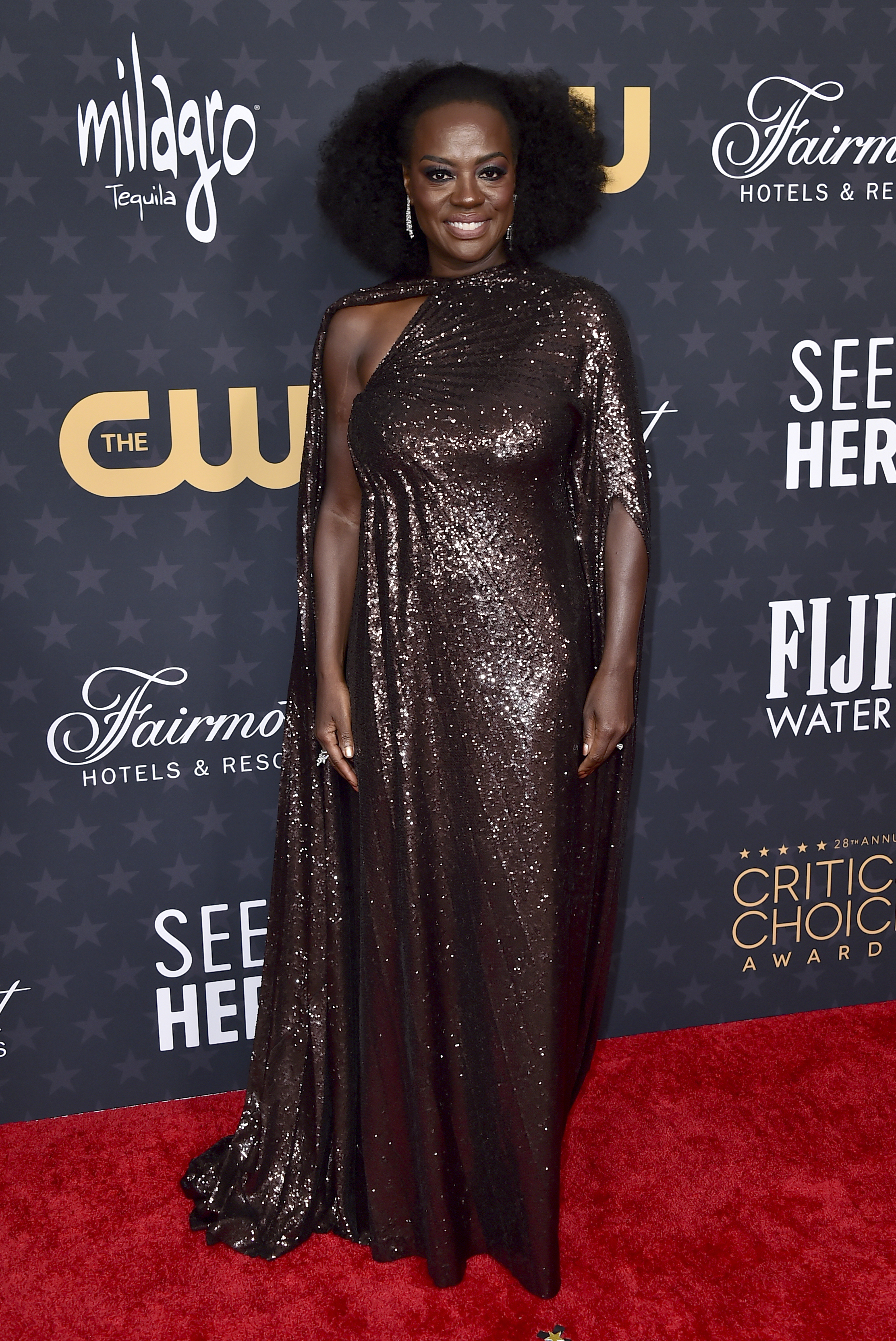 Viola Davis wearing a dark bronze sequined floor-length dress with a cape-like shoulder and a slight train