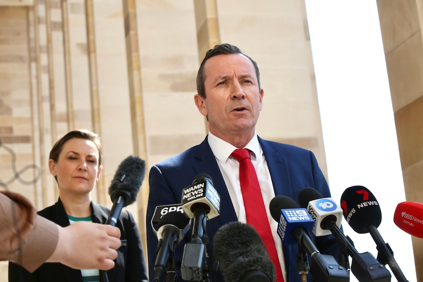 Mark McGowan speaks into microphones with Amber-Jade Sanderson pictured in the background