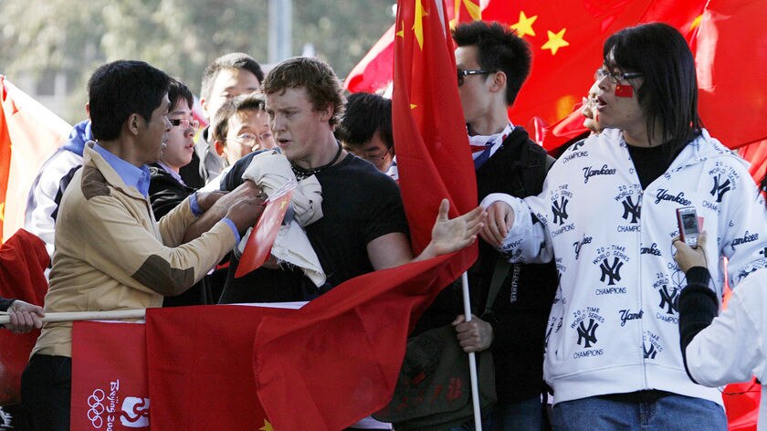 A pro-Tibet protester is stopped by supporters of the 2008 Beijing Olympic Games during the relay