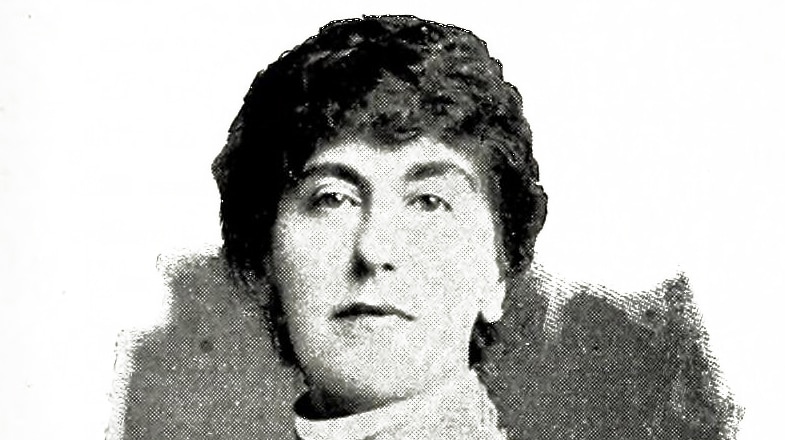 A black and white early 20th century head shot of an unsmiling woman in a high collar