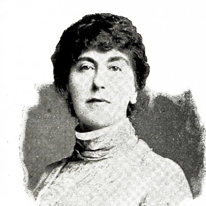 A black and white early 20th century head shot of an unsmiling woman in a high collar