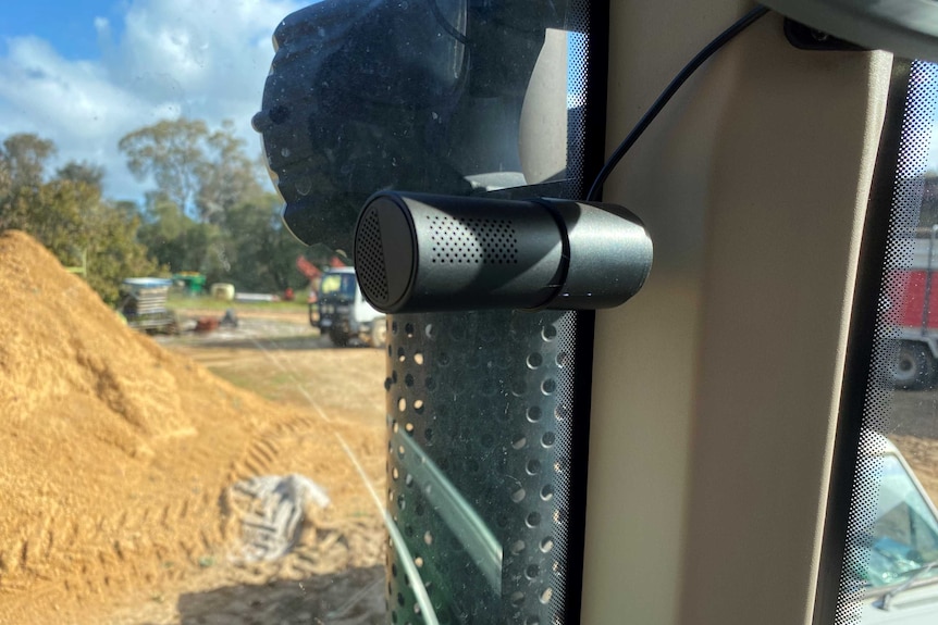 A close up photo of a dashboard camera inside the front window of a tractor.