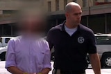 A still of Mosman bomb fraud suspect Paul Douglas Peters as he is led from a US court in  Louisville