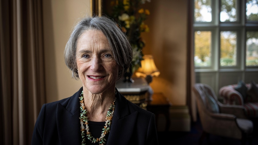 A middle aged woman poses for a photo inside Government House