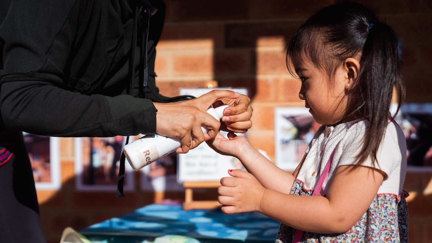 Girl at childcare centre receives hand sanitiser