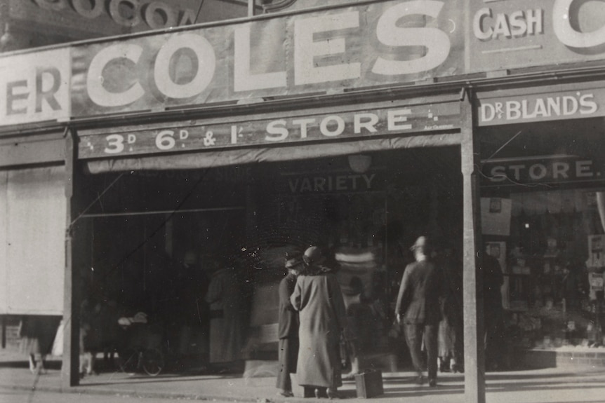 An early 1900s black and white photo of a store with a sign that reads Coles
