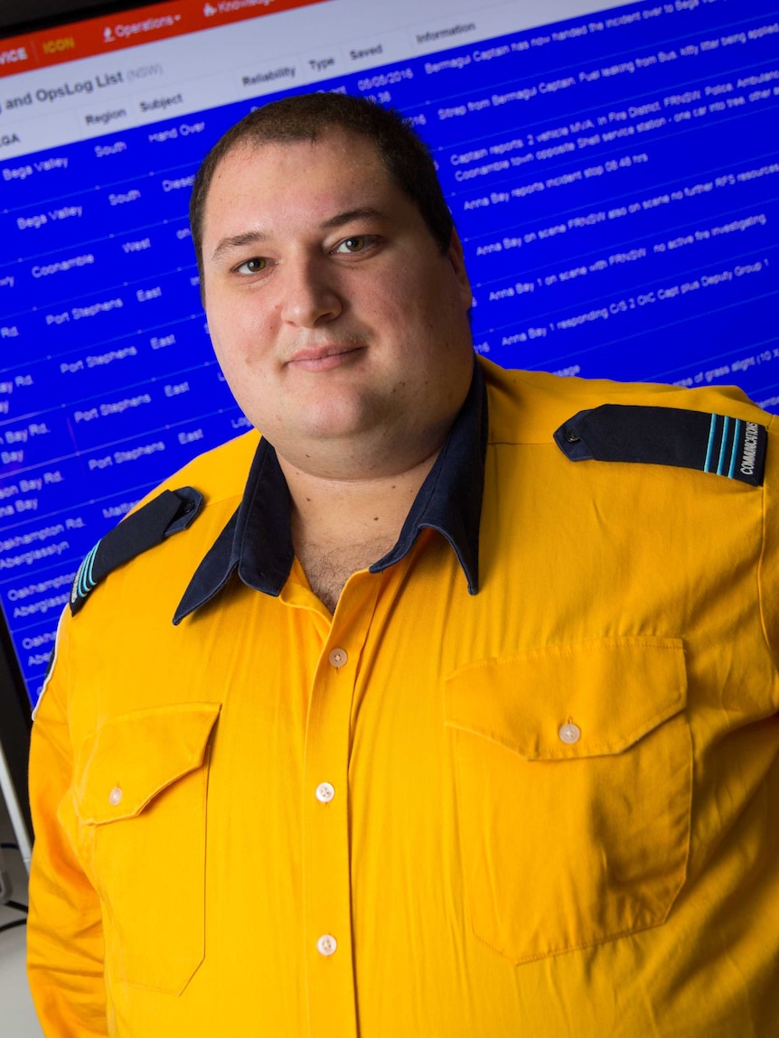 Mark Glease stands in front of computer screens.