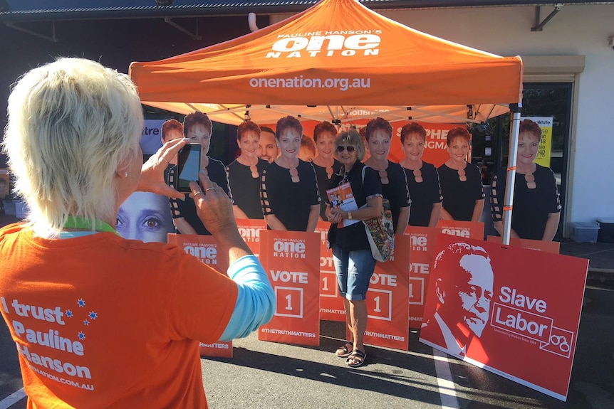 Longman resident Patricia Rogers gets at photo in front of a cardboard cut-out of One Nation Leader Pauline Hanson.