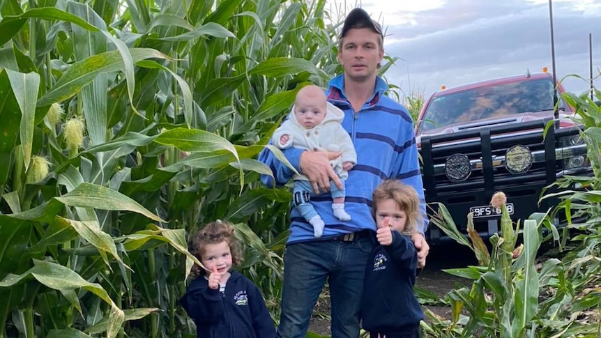 Sam Monk and his children next to a corn crop