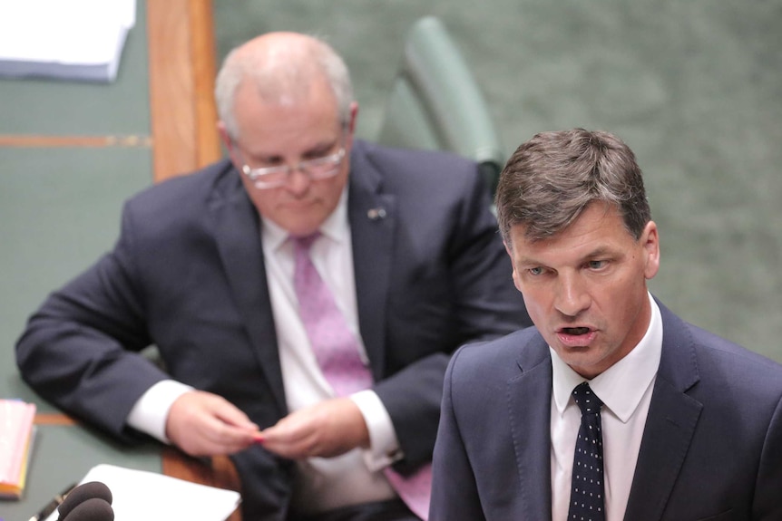 Angus Taylor speaks at the shipping box while Scott Morrison listens in