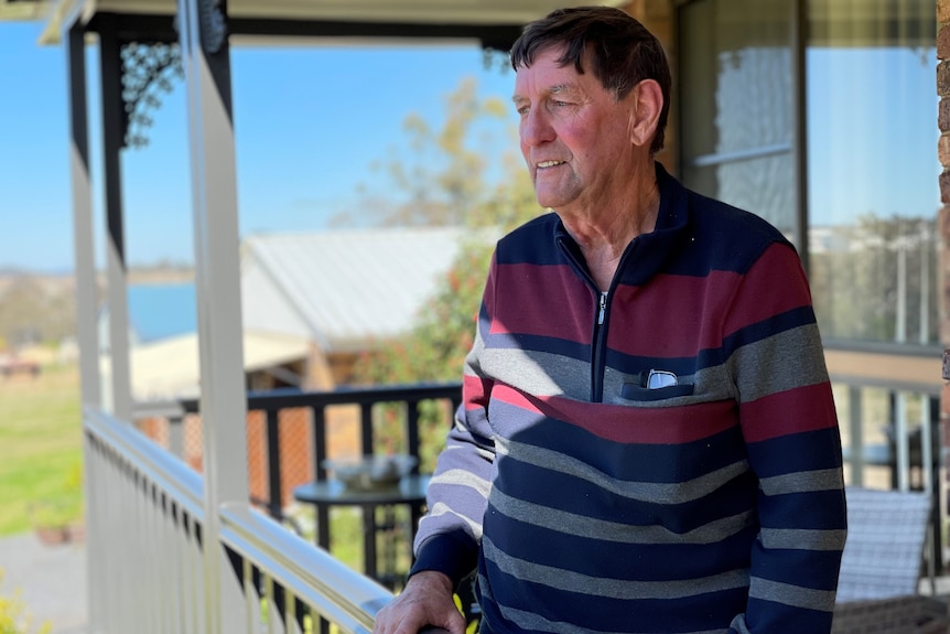 A man in a jumper stares over a veranda in Toowoomba