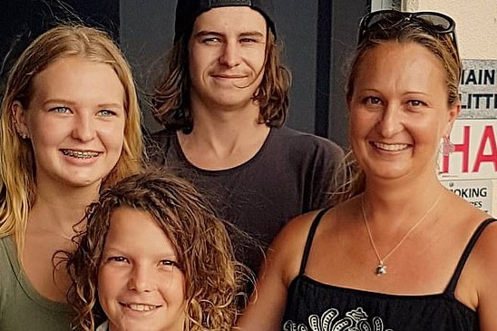 Smiling family photo, with mother and three children in their early and late teens.