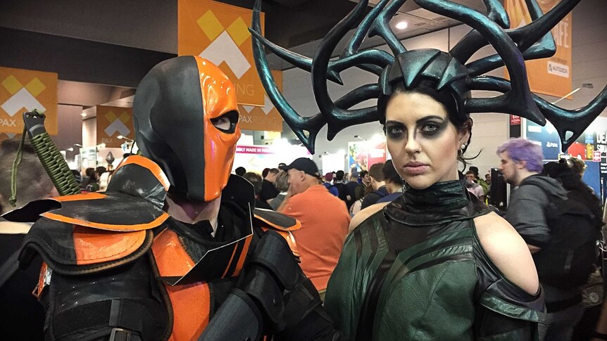 A couple dressed up in orange and black costumes at PAX Australia in Melbourne.