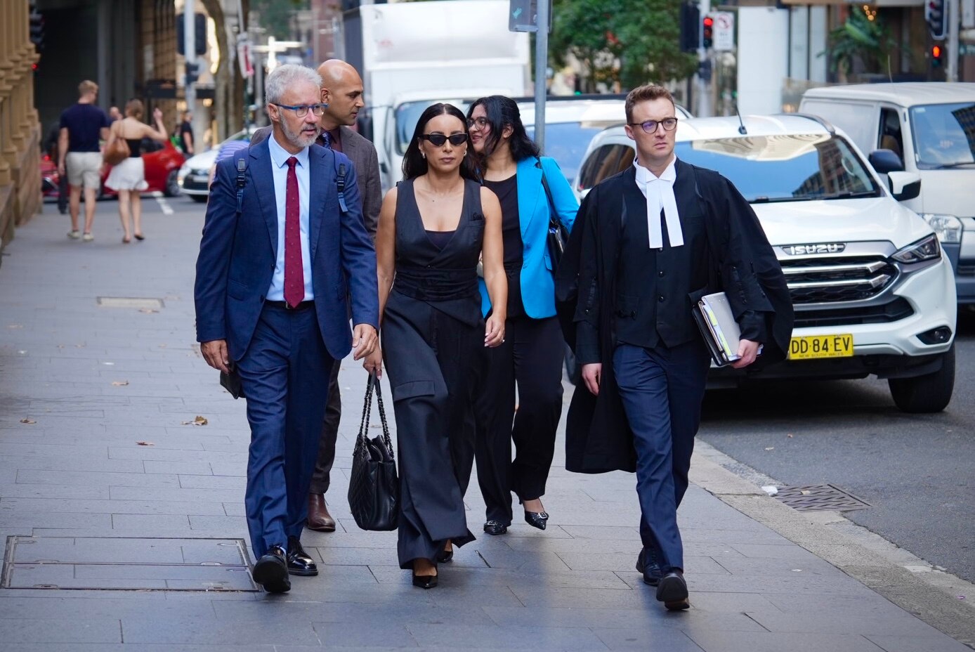 A group of people in suits walk toward a court.