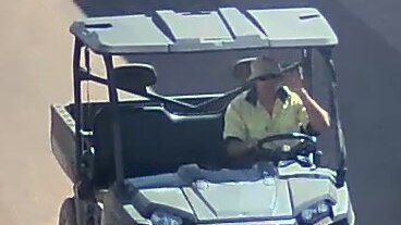 A CCTV image of a man in a yellow hi-vis shirt driving a buggy