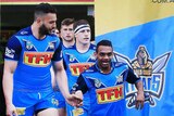 Gold Coast Titans captain runs out onto the game field holding hands with a smiling Anno Pitt