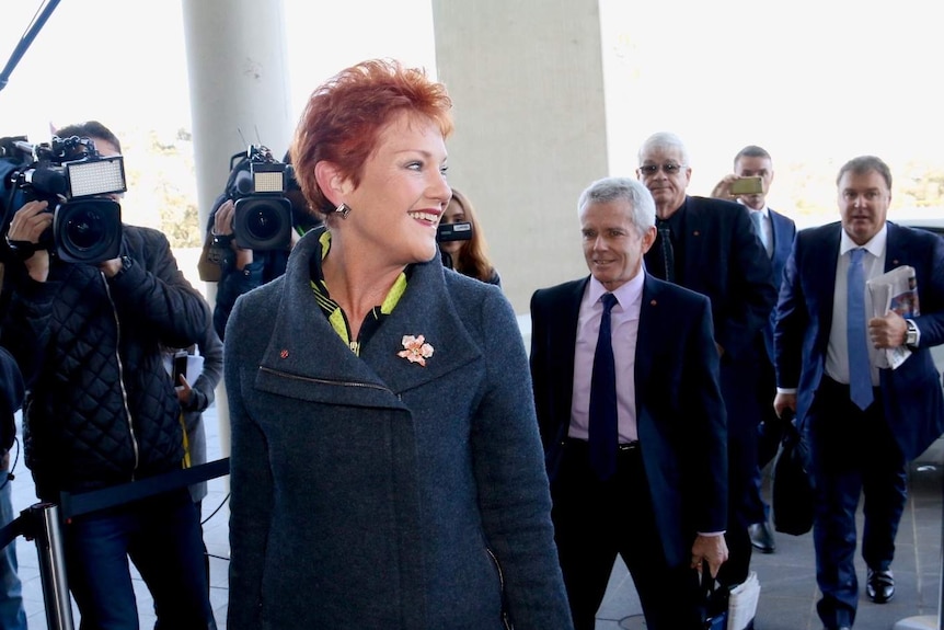 Senator Pauline Hanson smiles for the cameras as she arrives for Senate School.