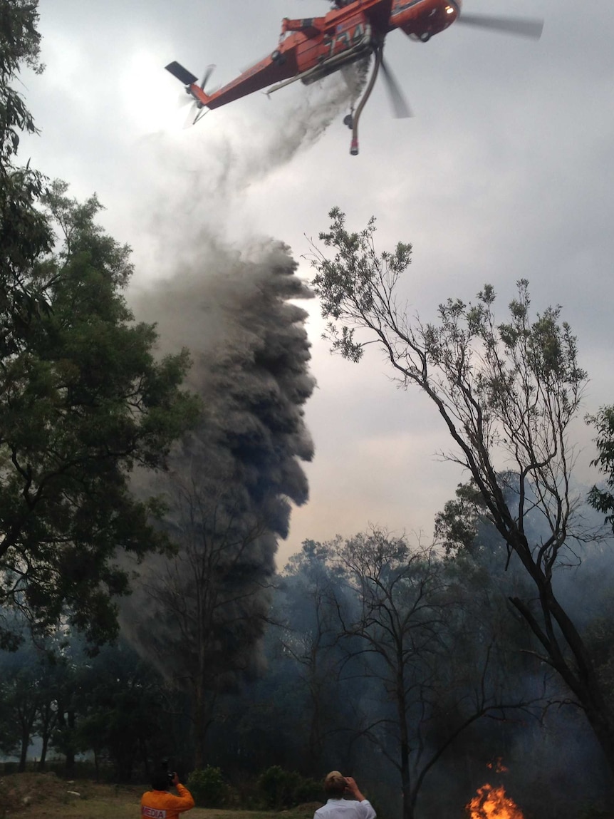 A large air crane dumps water on the blaze at Loxford.