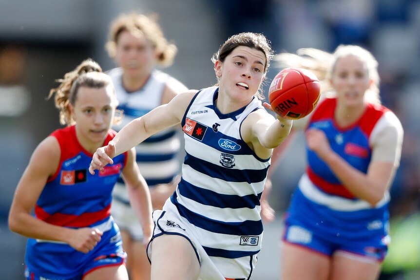 Darcy Moloney stretches her hand out to try to reach the football