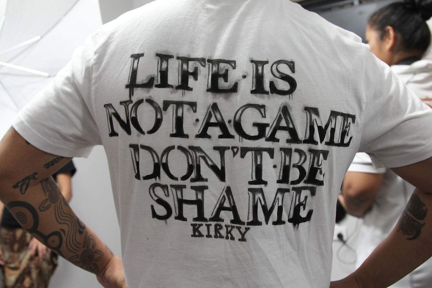 a man wearing a white shirt with words "life is not a game, don't be shame"