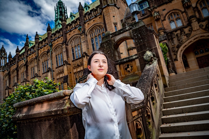 A young woman standing in front of an old building.