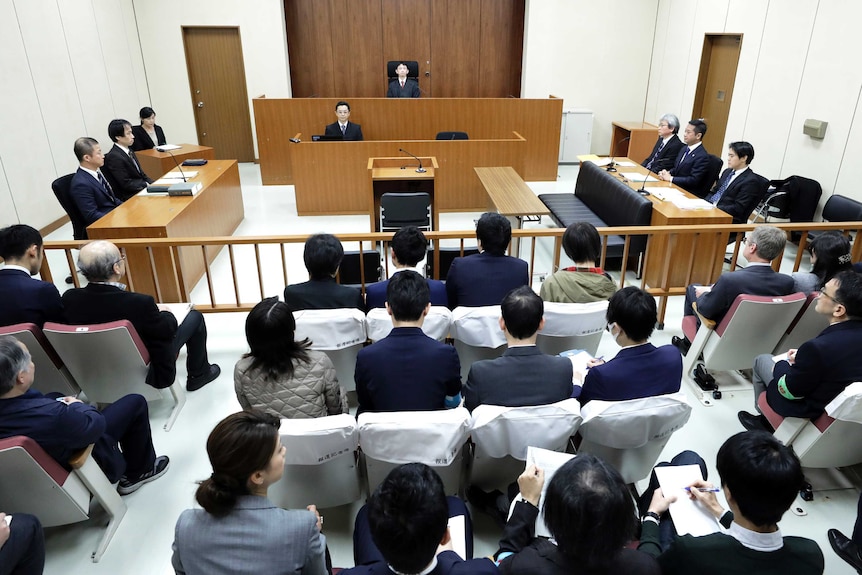 Judge Yuichi Tada, top center, and spectators sit in a courtroom ahead of Carlos Ghosn's court hearing.