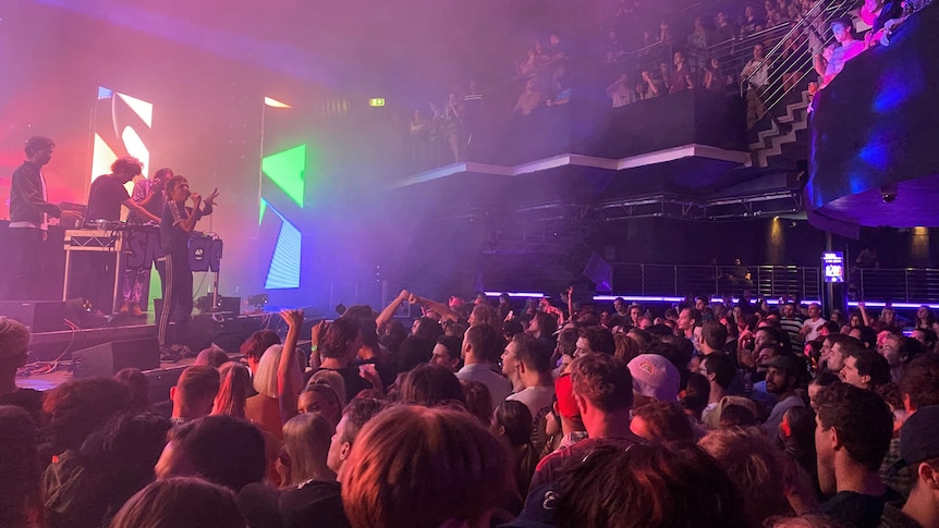 People packed inside a nightclub, watching a show.