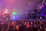 People packed inside a nightclub, watching a show.