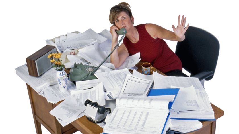 Woman at cluttered desk.