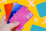 A person holds three debit cards for a story about why you don't need a credit card, plus tips for getting rid of one.