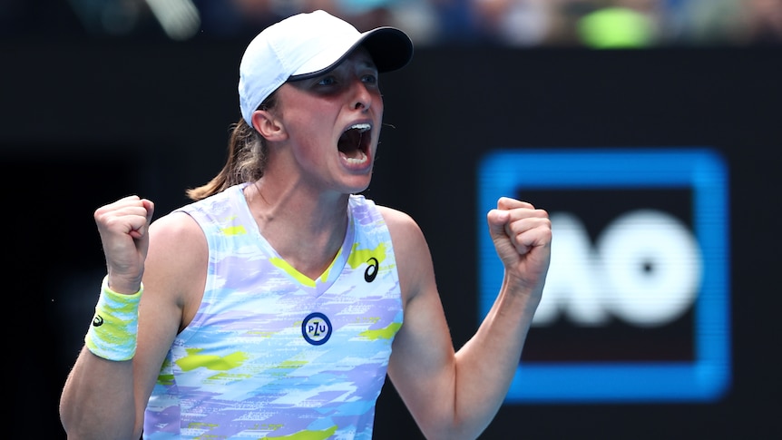 A Polish female tennis player pumps her fists as she celebrates winning her Australian Open quarterfinal.