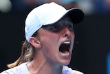 A Polish female tennis player pumps her fists as she celebrates winning her Australian Open quarterfinal.